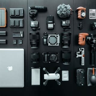 Des pièces détachées d'un appareil photo posées et organisées sur une surface sombre 